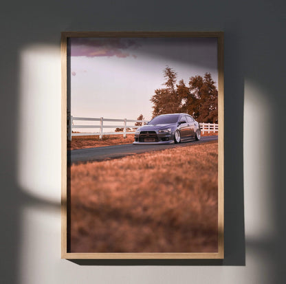 Mitsubishi Evo 10 poster wall art with car on country road at sunset in wooden frame.