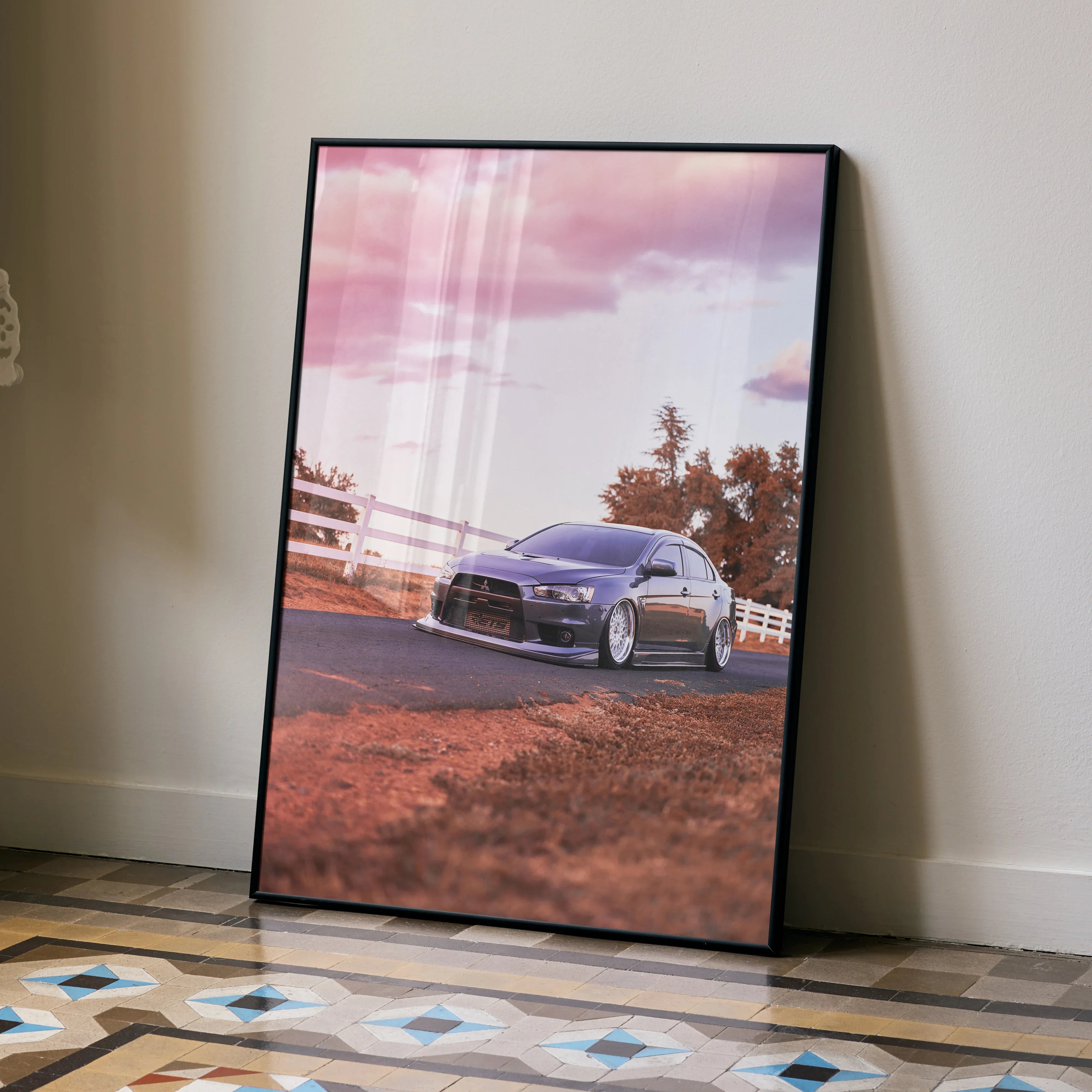 Mitsubishi Evo 10 poster with sunset backdrop, sleek sports car wall art in black frame.