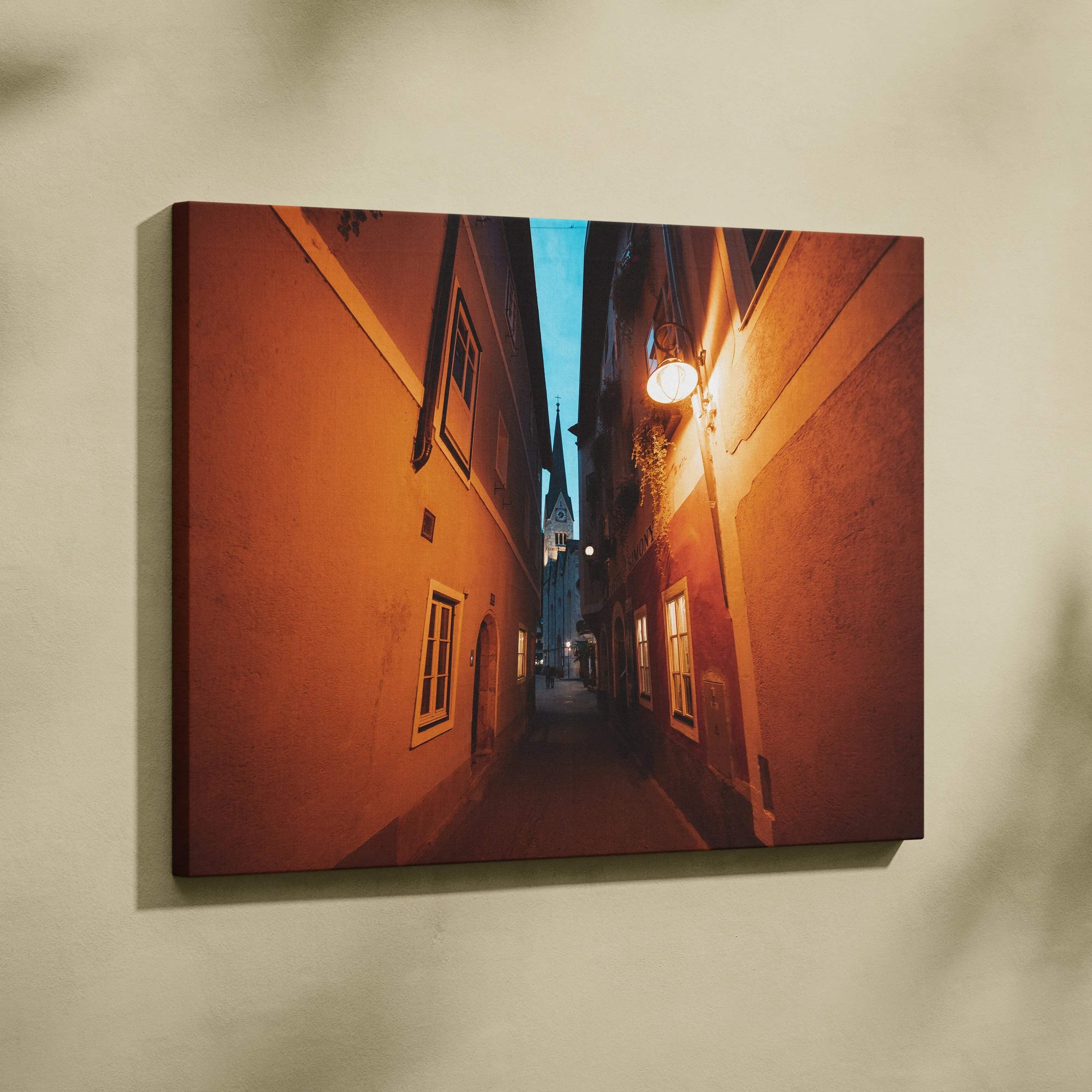 Narrow alleyway between tall buildings at dusk with warm lighting on canvas wall art print.