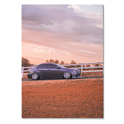 Mitsubishi Evo 10 parked by white fence at sunset wall art poster with warm tones.