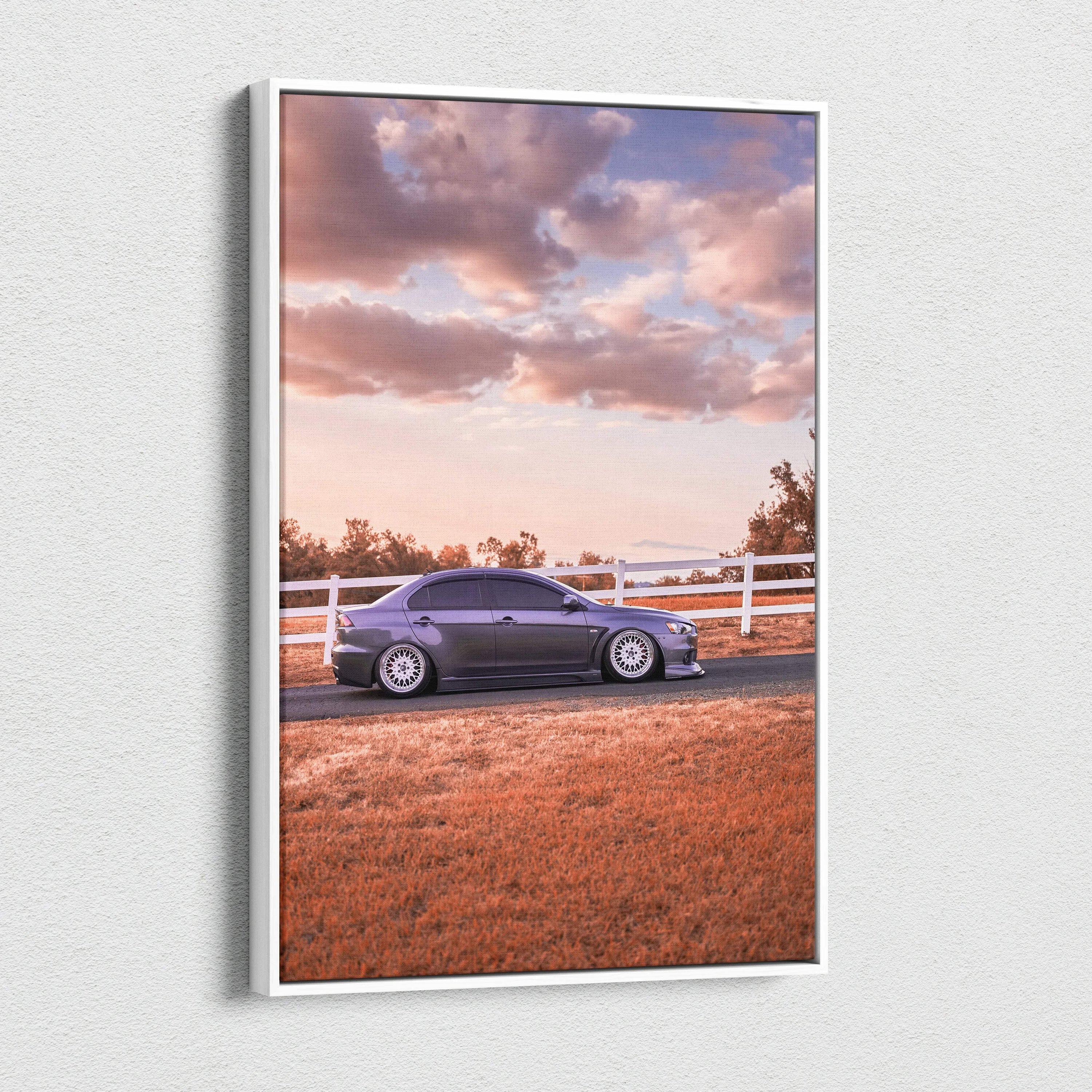 Vertical canvas wall art featuring a Mitsubishi Evo 10 parked by a white fence under a cloudy sky at sunset.
