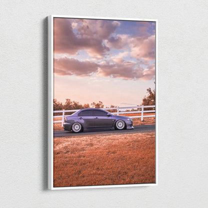Vertical canvas wall art featuring a Mitsubishi Evo 10 parked by a white fence under a cloudy sky at sunset.