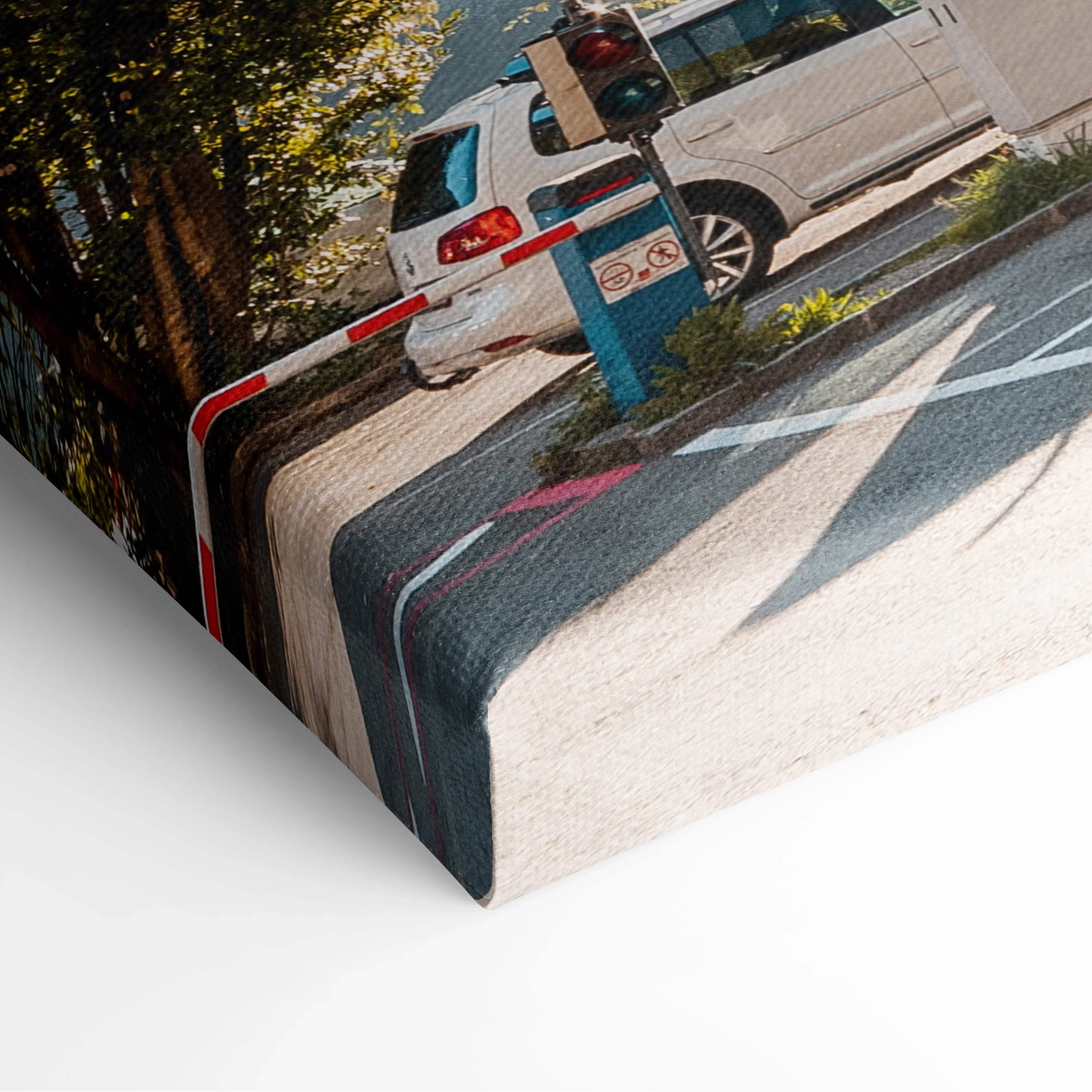 Warm sunlit architectural canvas wall art featuring a white volkswagen car stopped at a red and white barrier in an alpine village