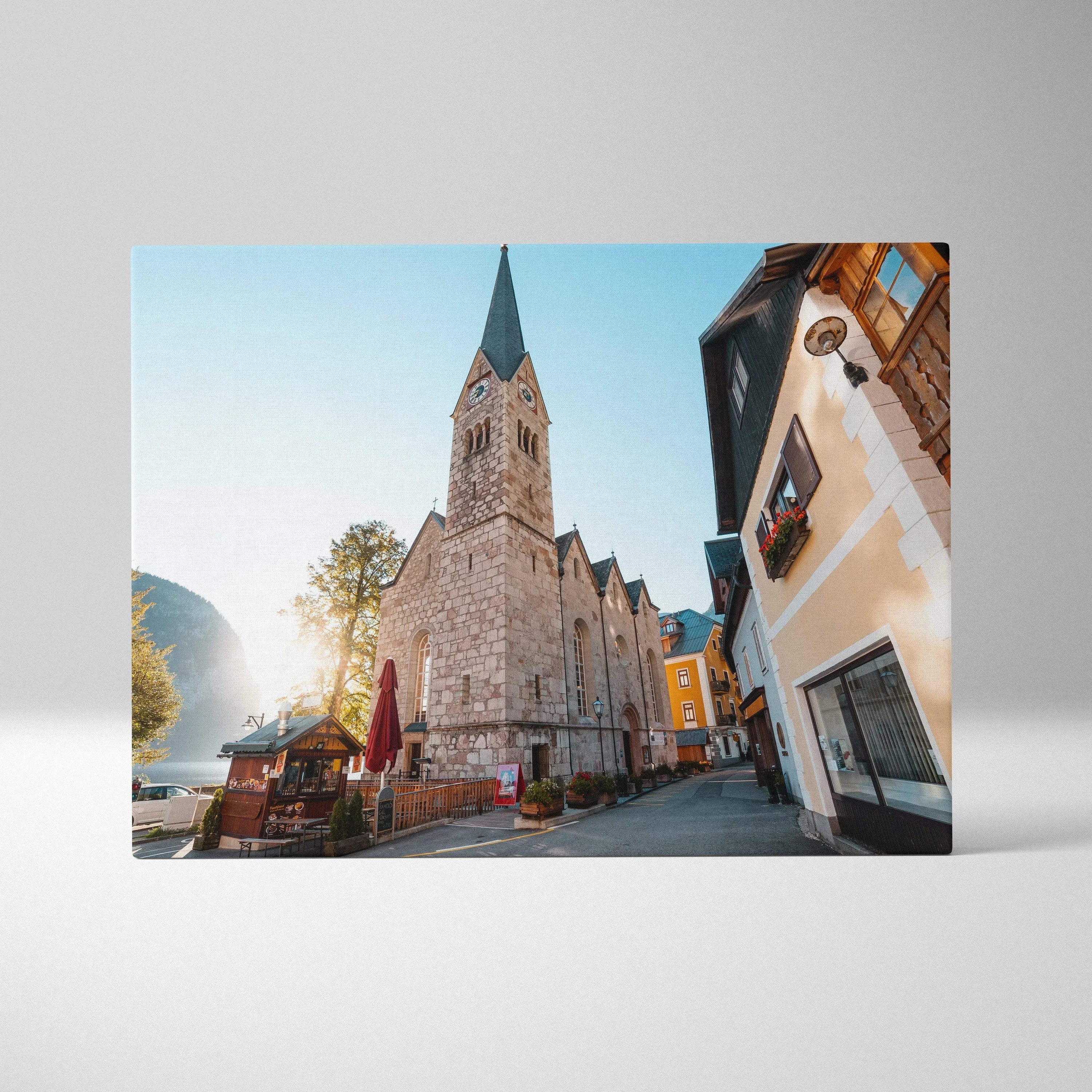 Canvas wall art featuring a historic stone church with a tall steeple under a clear blue sky, vibrant sunlight illuminating.