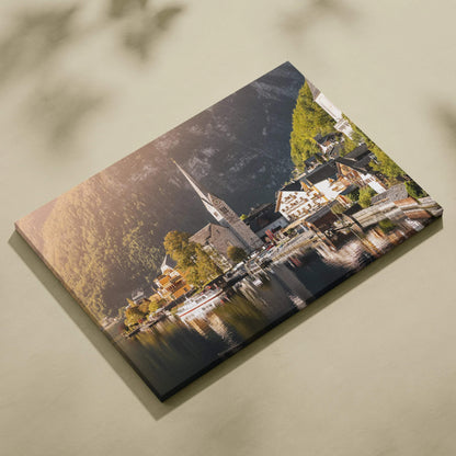 Canvas wall art print featuring a serene lakeside village with a church steeple, surrounded by forested hills at sunset.