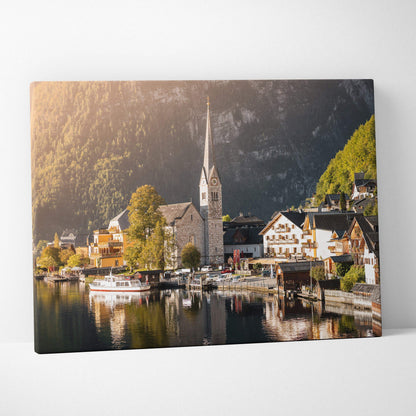 Canvas wall art featuring a serene lakeside village with traditional buildings and a tall church steeple, set against.