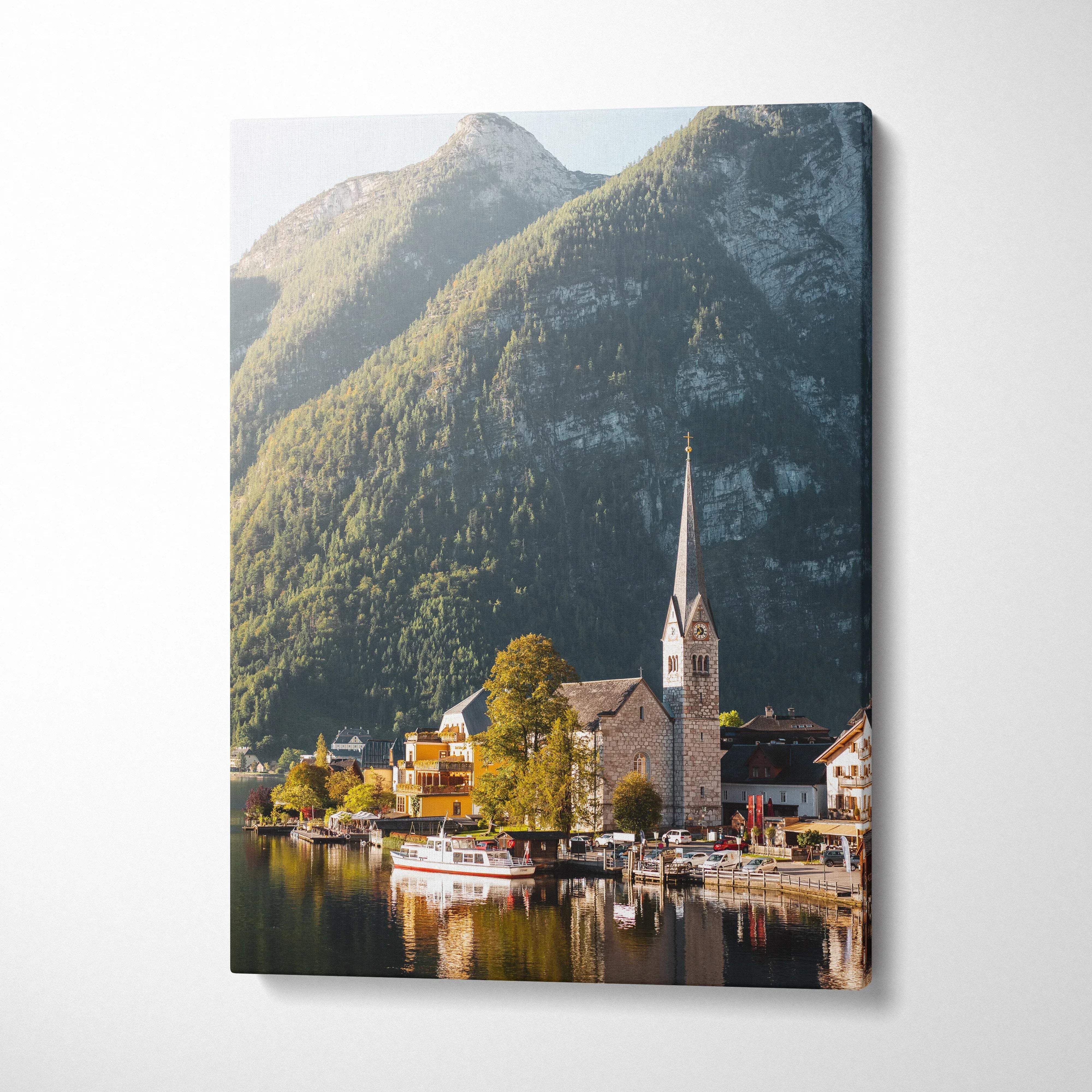 Canvas wall art featuring a serene lakeside village with a church steeple and lush mountain backdrop.