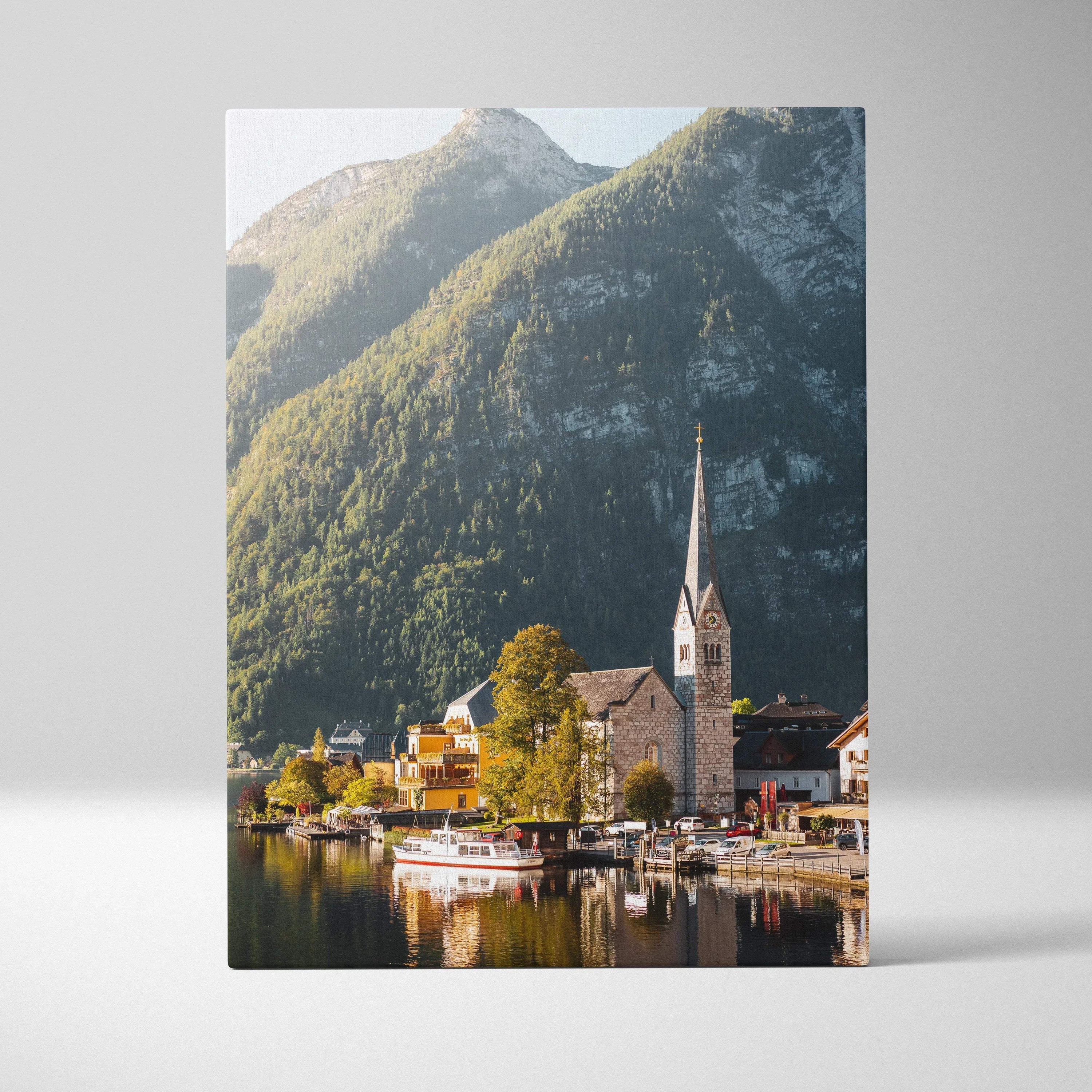 Vertical canvas wall art featuring a serene mountain village with a church and boats by the water.