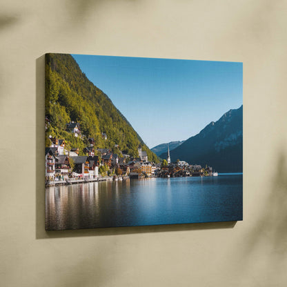 Canvas wall art featuring a serene lakeside village with colorful buildings, green mountains, and clear blue sky.