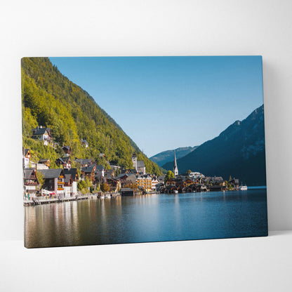 Canvas wall art print featuring a serene lakeside village with colorful buildings and green mountains under a clear blue sky.