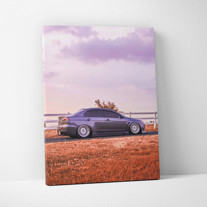 Mitsubishi Evo 10 parked by white fence with orange grass and purple sky canvas wall art.