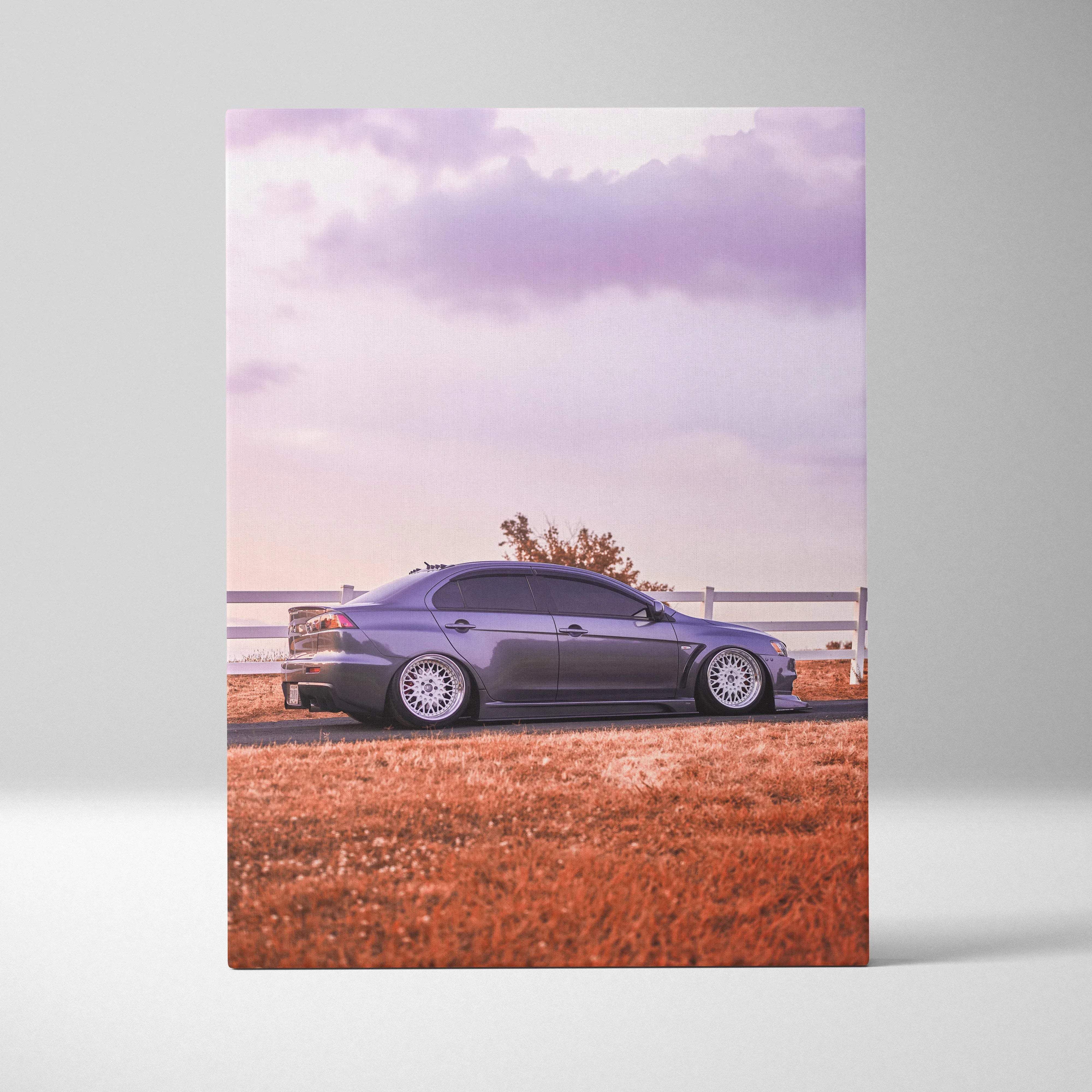 Canvas wall art featuring a sleek metallic gray mitsubishi lancer evolution with white alloy wheels at purple sunset