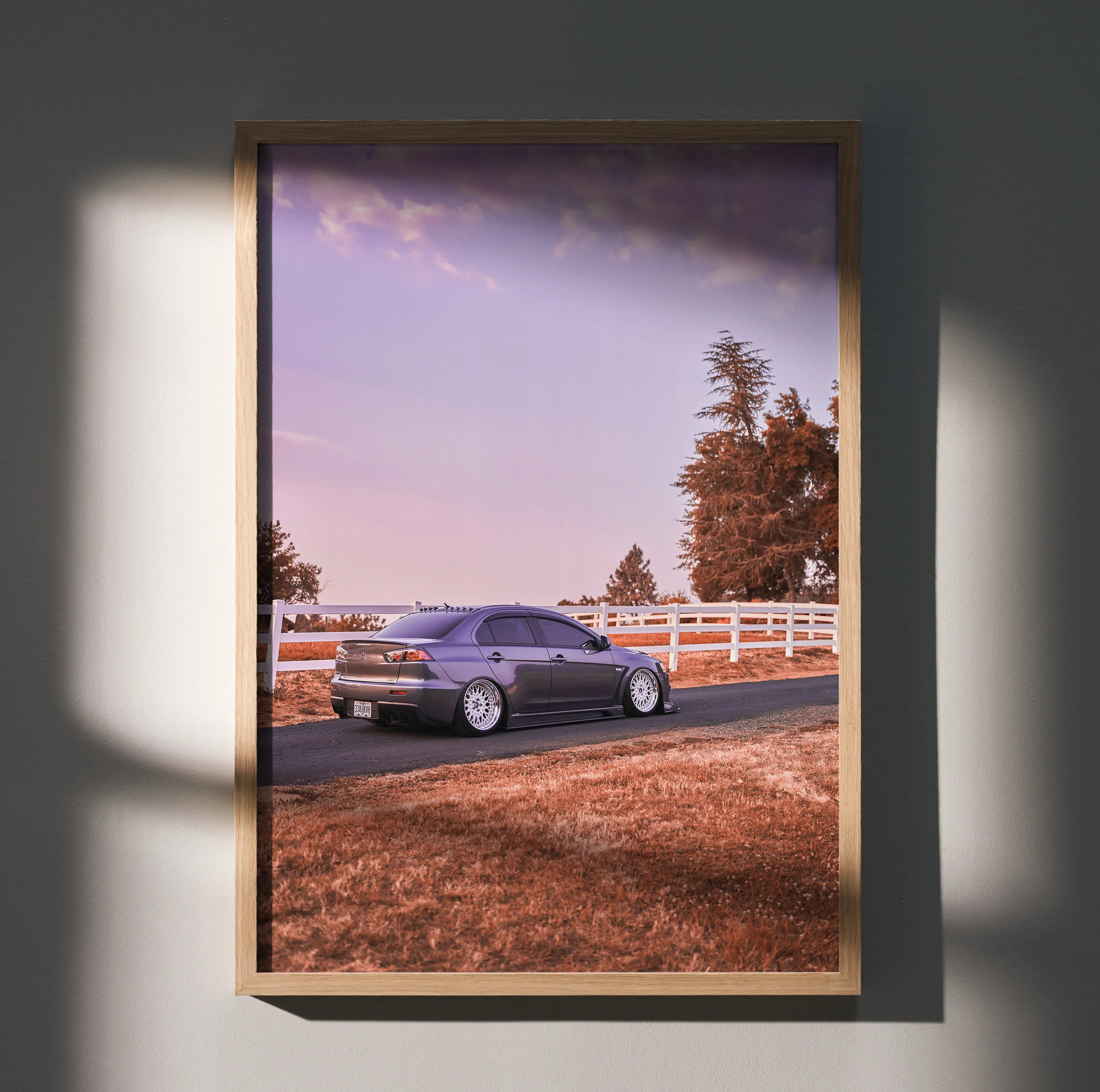 Mitsubishi Evo 10 poster with scenic road and autumn trees wall art in wooden frame.