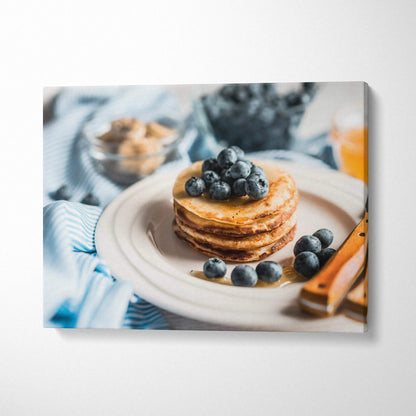 Canvas wall art featuring a stack of blueberry pancakes on a white plate with fresh blueberries and striped fabric decor.