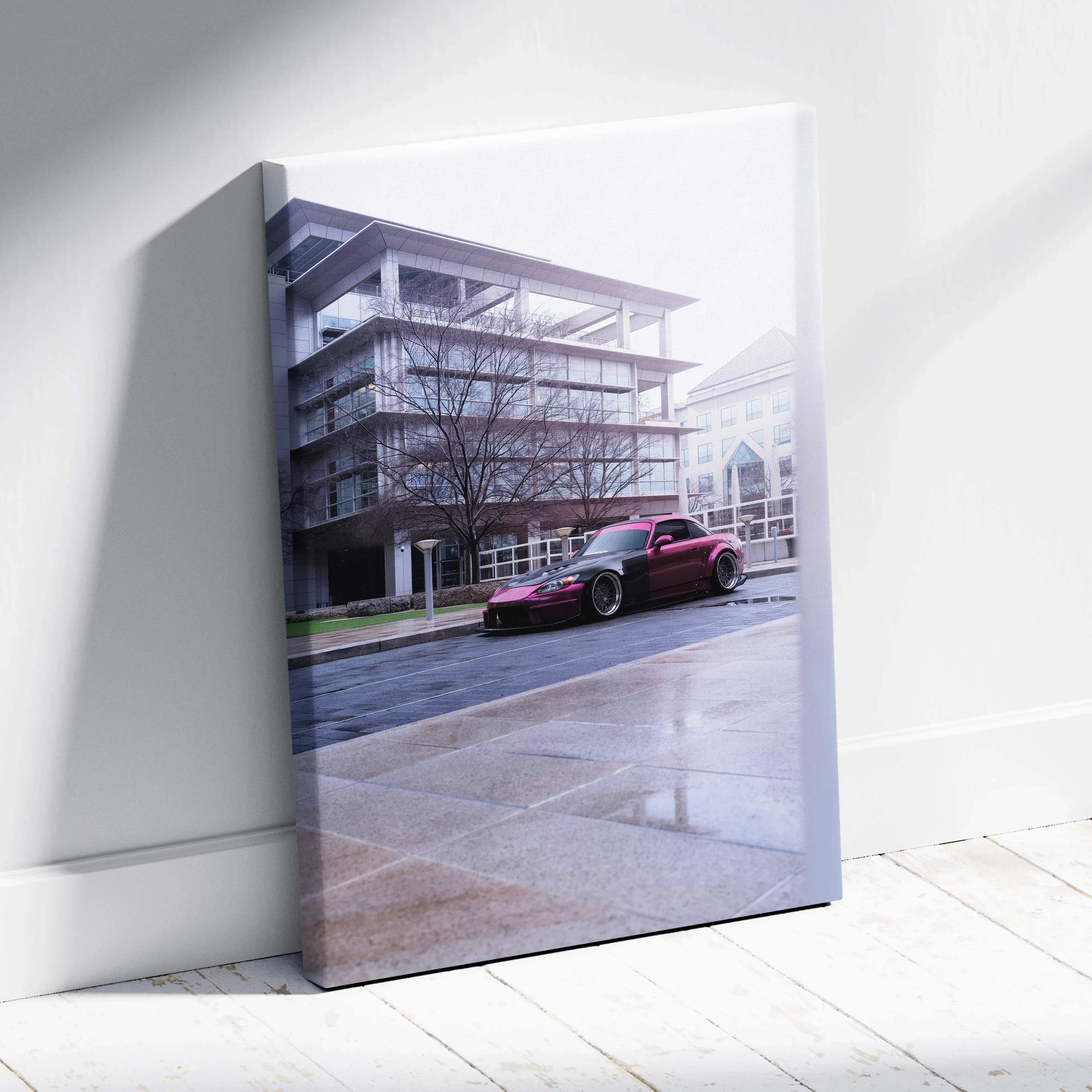 A vibrant red and black modified honda s2000 sports car canvas wall art print leaning against a white wall