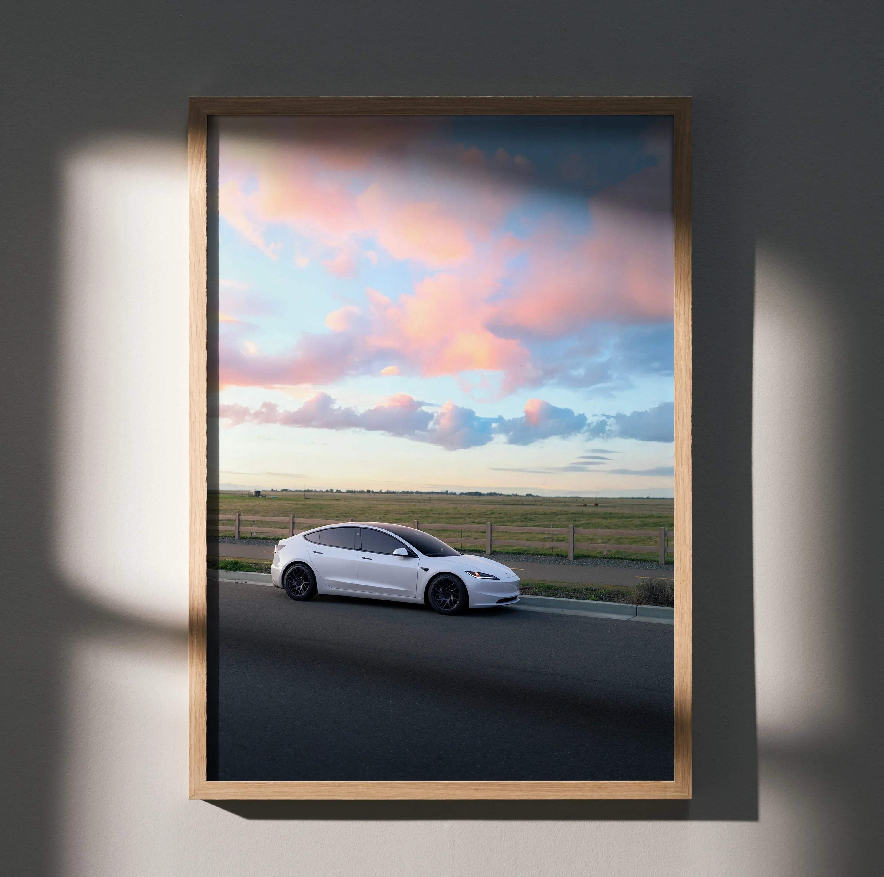 Tesla Model 3 Highland driving on road at sunset poster wall art in wooden frame.