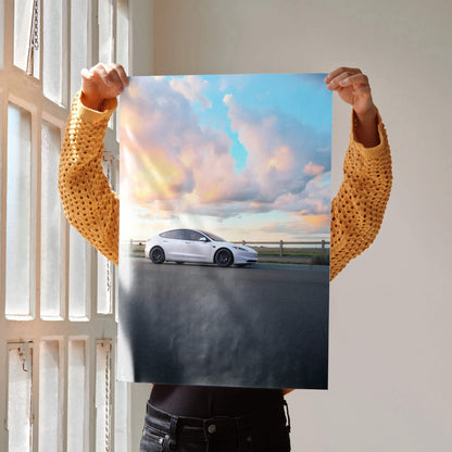 Tesla Model 3 Highland parked by a road under a colorful sunset sky poster wall art.