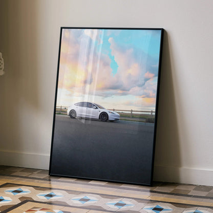 Tesla Model 3 Highland poster with white car against a colorful sunset sky, wall art in black frame.