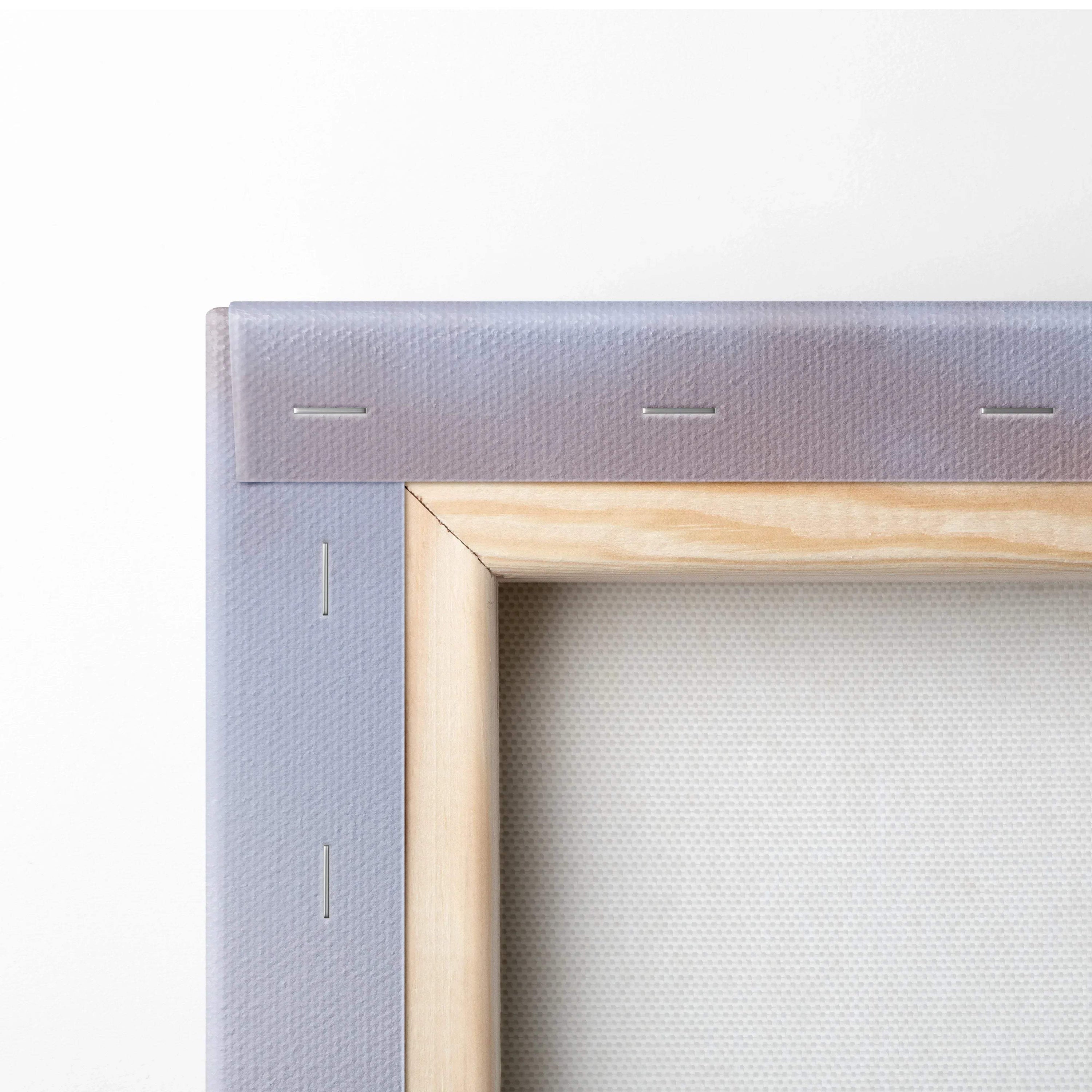 Close-up of wooden frame and gray canvas edge with visible staples for wall art canvas print.
