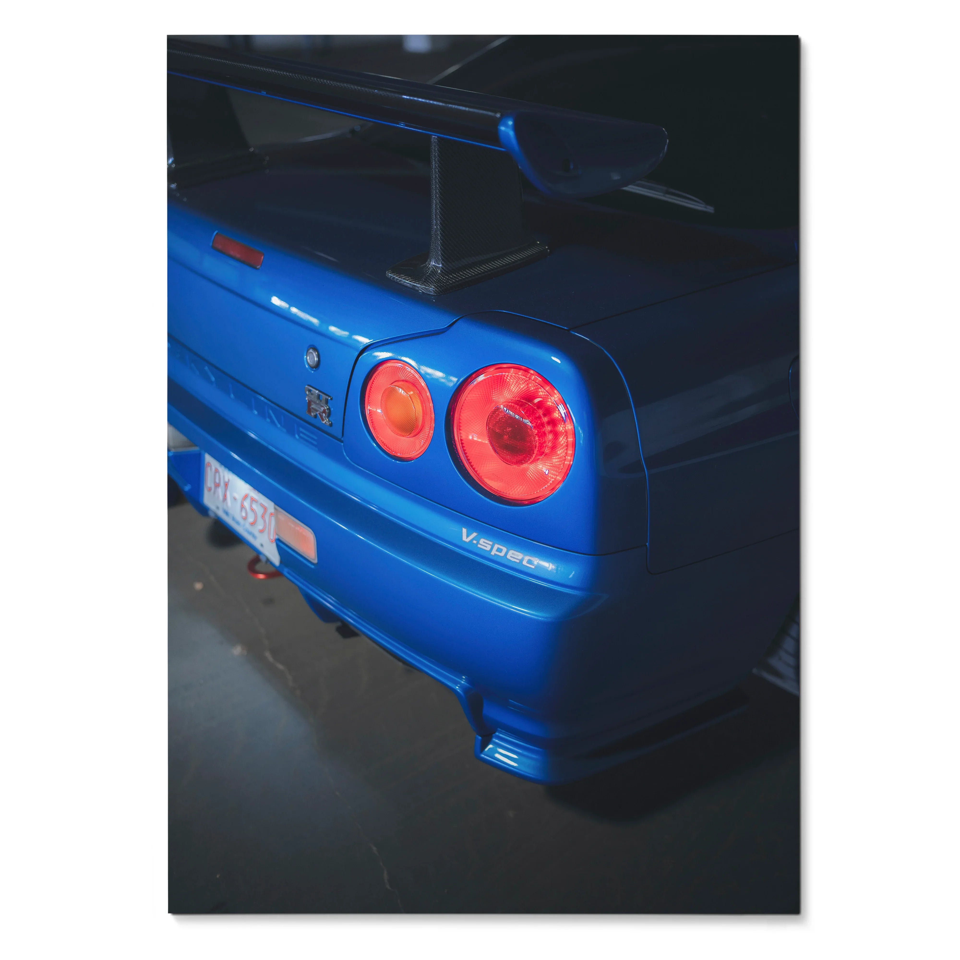 Nissan R34 GTR Skyline rear close-up poster with glowing taillights and blue paint wall art.