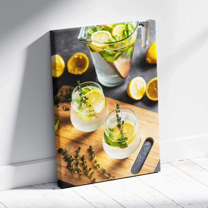 Canvas wall art featuring vibrant lemon water in clear glasses with fresh lemon slices and herbs on a wooden board.