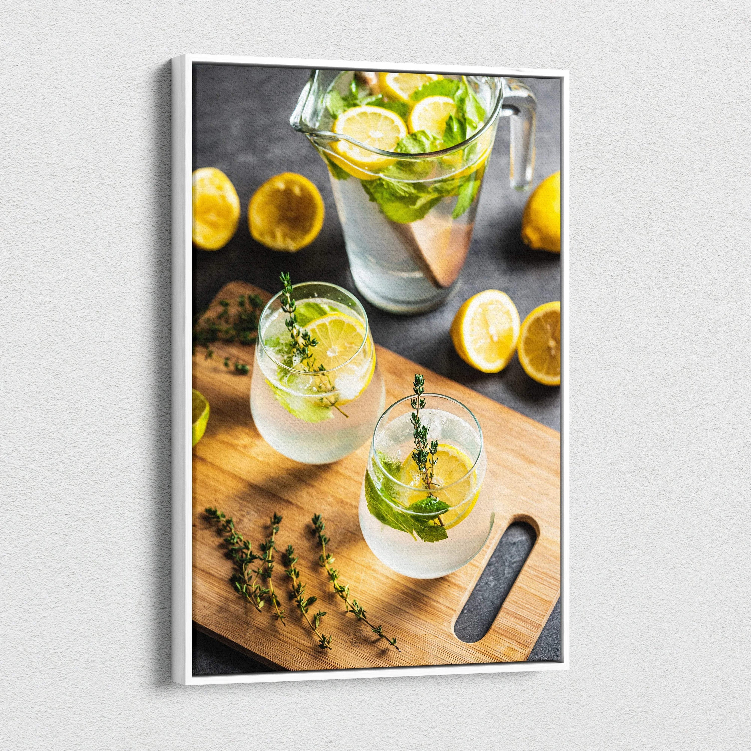 Canvas wall art featuring vibrant lemon water in clear glasses on a wooden cutting board with fresh lemon slices and herbs.