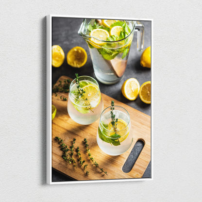 Canvas wall art featuring vibrant lemon water in clear glasses on a wooden cutting board with fresh lemon slices and herbs.