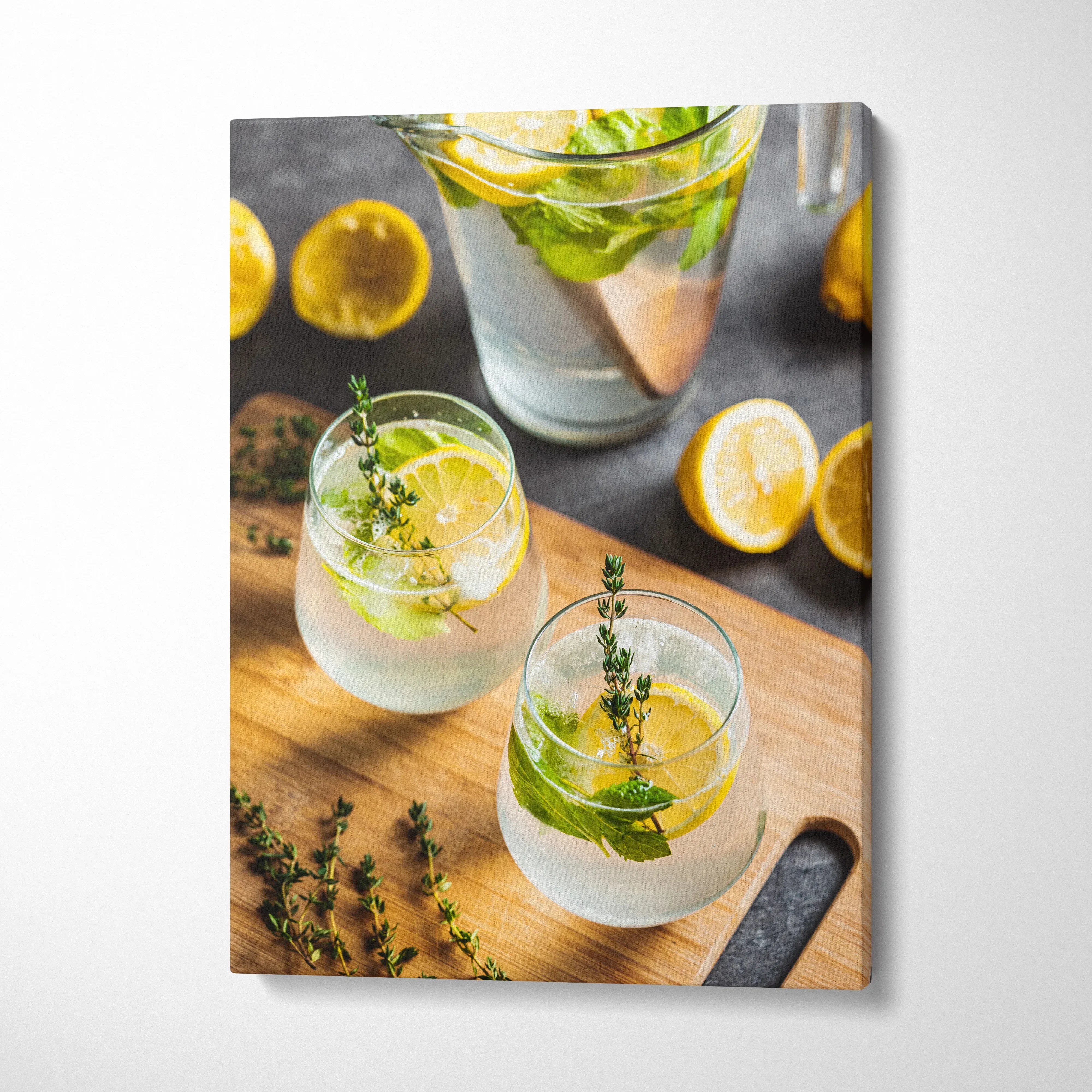 Canvas wall art featuring vibrant lemon water in glasses with fresh herbs and lemon slices on wooden surface for kitchen.