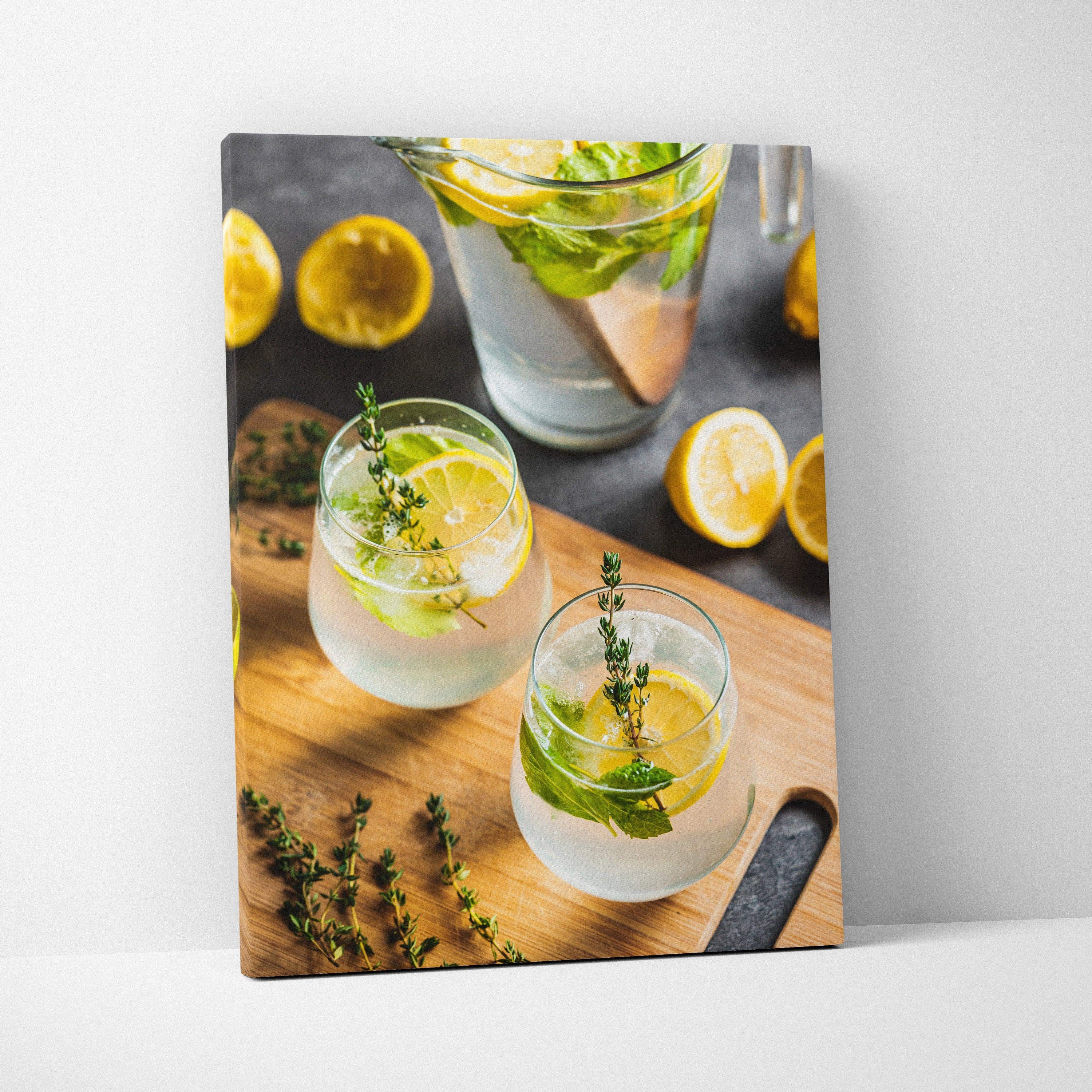 Canvas wall art featuring vibrant lemon water in clear glasses with fresh herbs on wooden surface, kitchen decor.