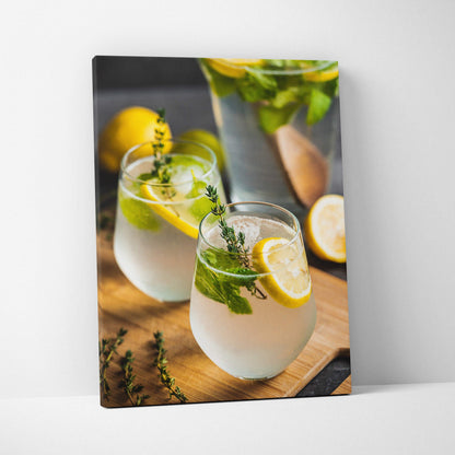 Vertical canvas wall art decor featuring vibrant lemon water glasses with fresh herbs on wooden surface.