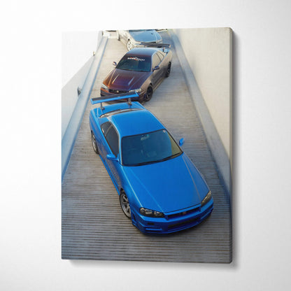 Vertical canvas art featuring blue and black Nissan R34 GTR cars parked on wood deck wall art.