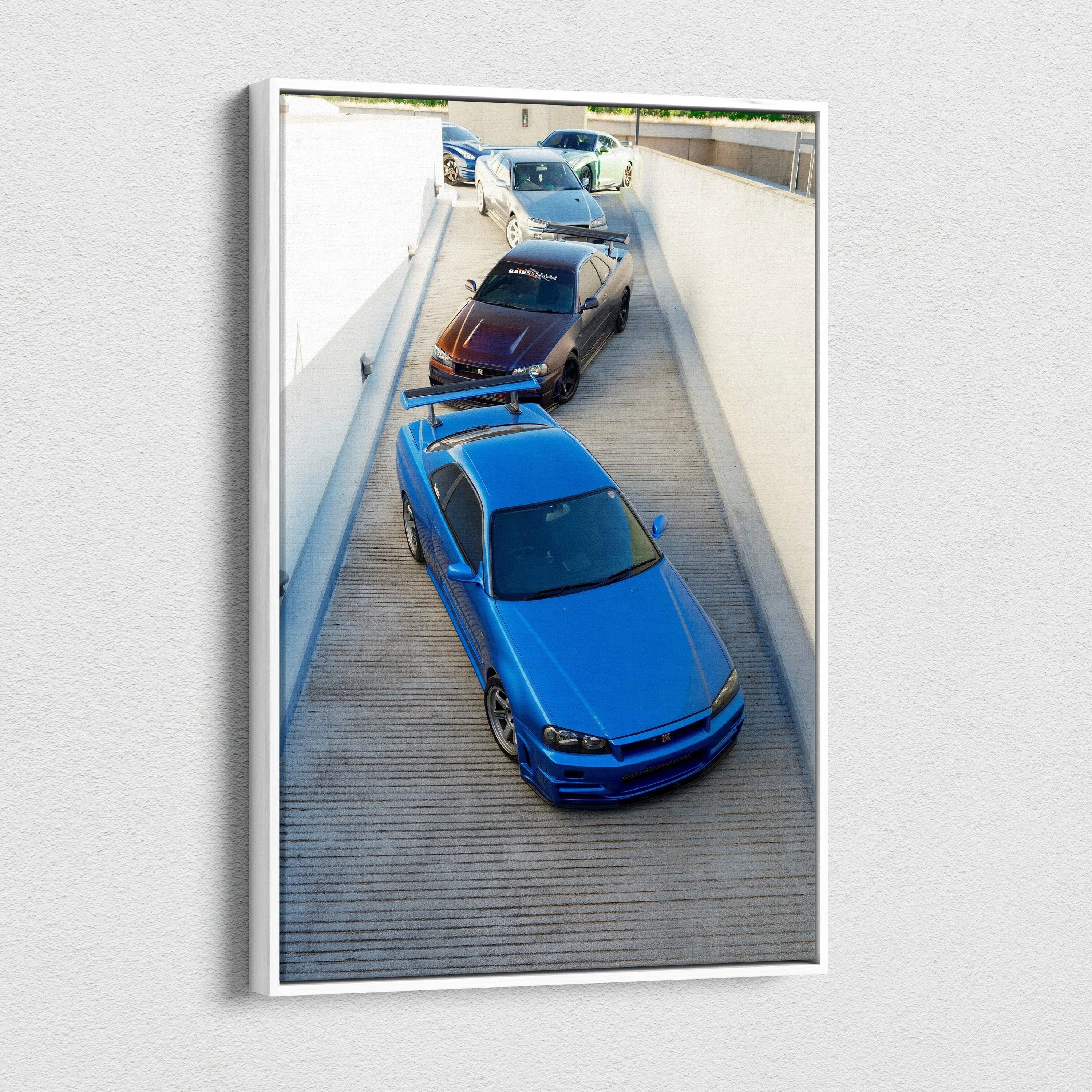 Vertical canvas wall art featuring a blue Nissan GTR R34 Skyline with two other models in a sleek museum-quality print.