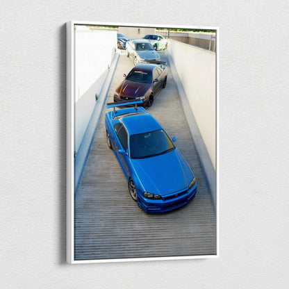 Vertical canvas wall art featuring a blue Nissan GTR R34 Skyline with two other models in a sleek museum-quality print.