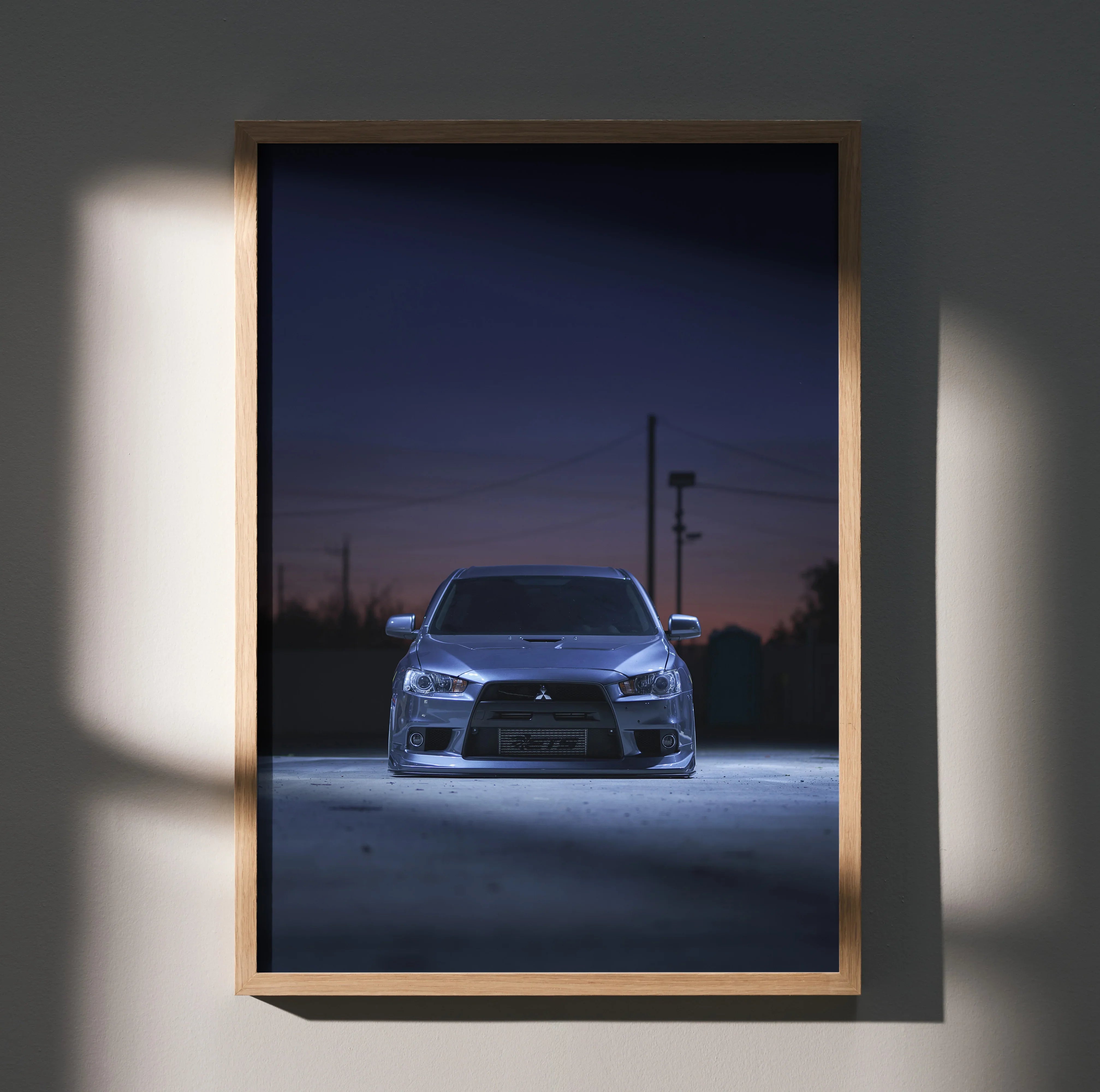 Mitsubishi Evo X in dark setting poster wall art with sleek car front view in wooden frame.