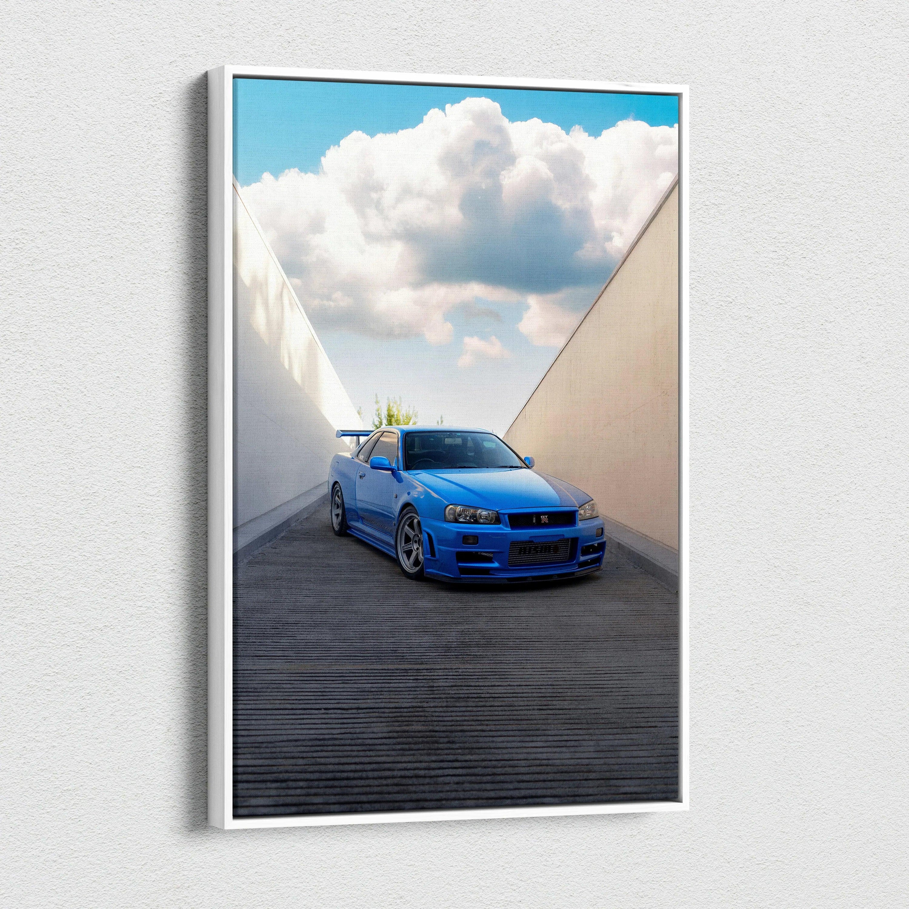 Vertical canvas art of a blue Nissan R34 GTR parked in a modern architectural alley with a bright cloudy sky background.