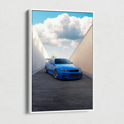 Vertical canvas art of a blue Nissan R34 GTR parked in a modern architectural alley with a bright cloudy sky background.