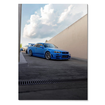Blue Nissan R34 GTR Skyline poster wall art with urban background and cloudy sky.