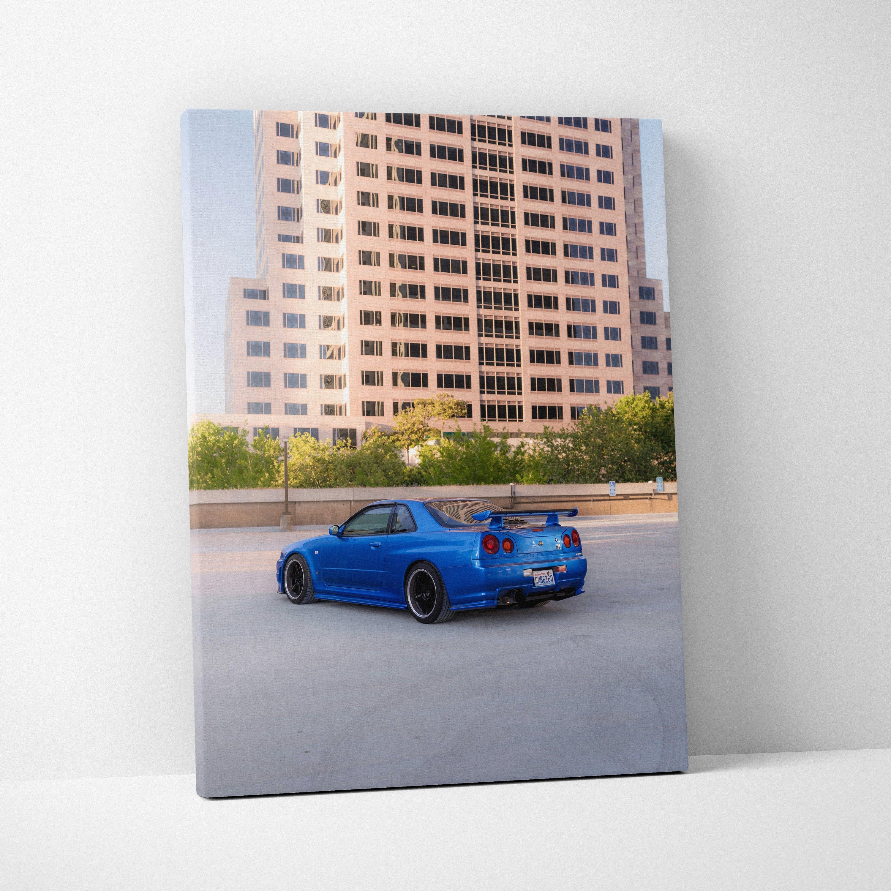 Nissan R34 GTR in blue on rooftop parking, vertical canvas wall art with cityscape background.