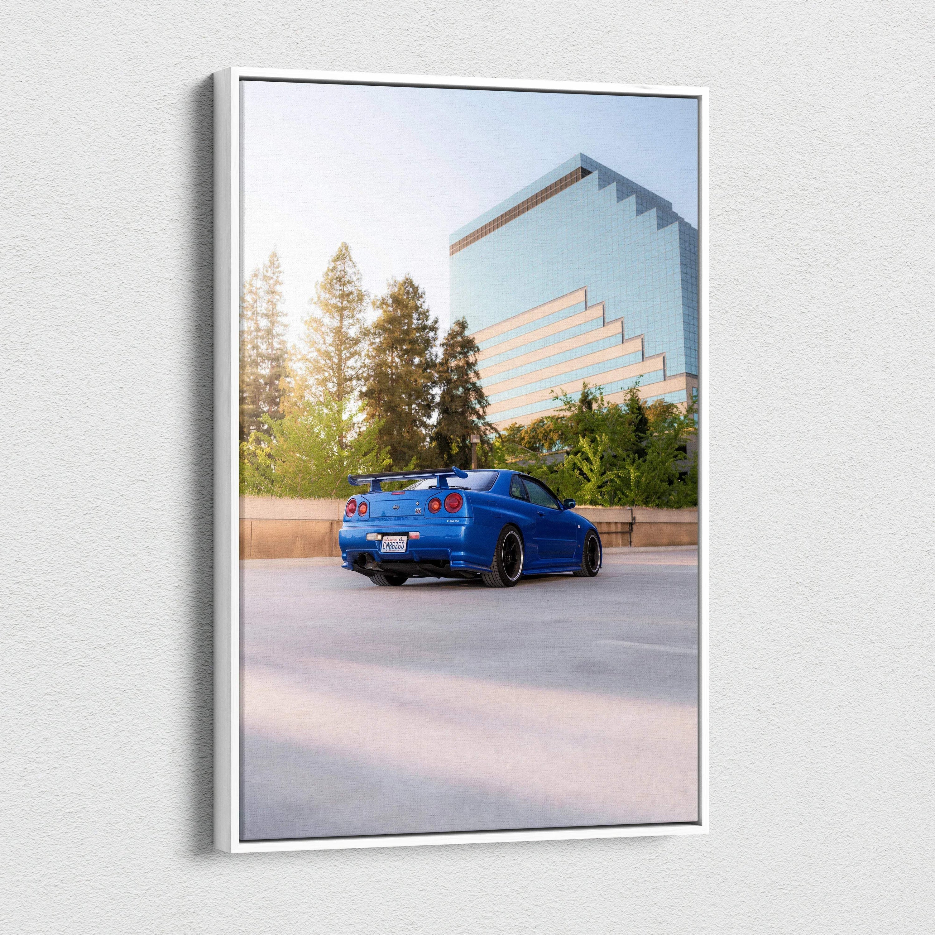 Vertical canvas art featuring a blue Nissan R34 GTR Skyline parked near a modern glass building and trees.