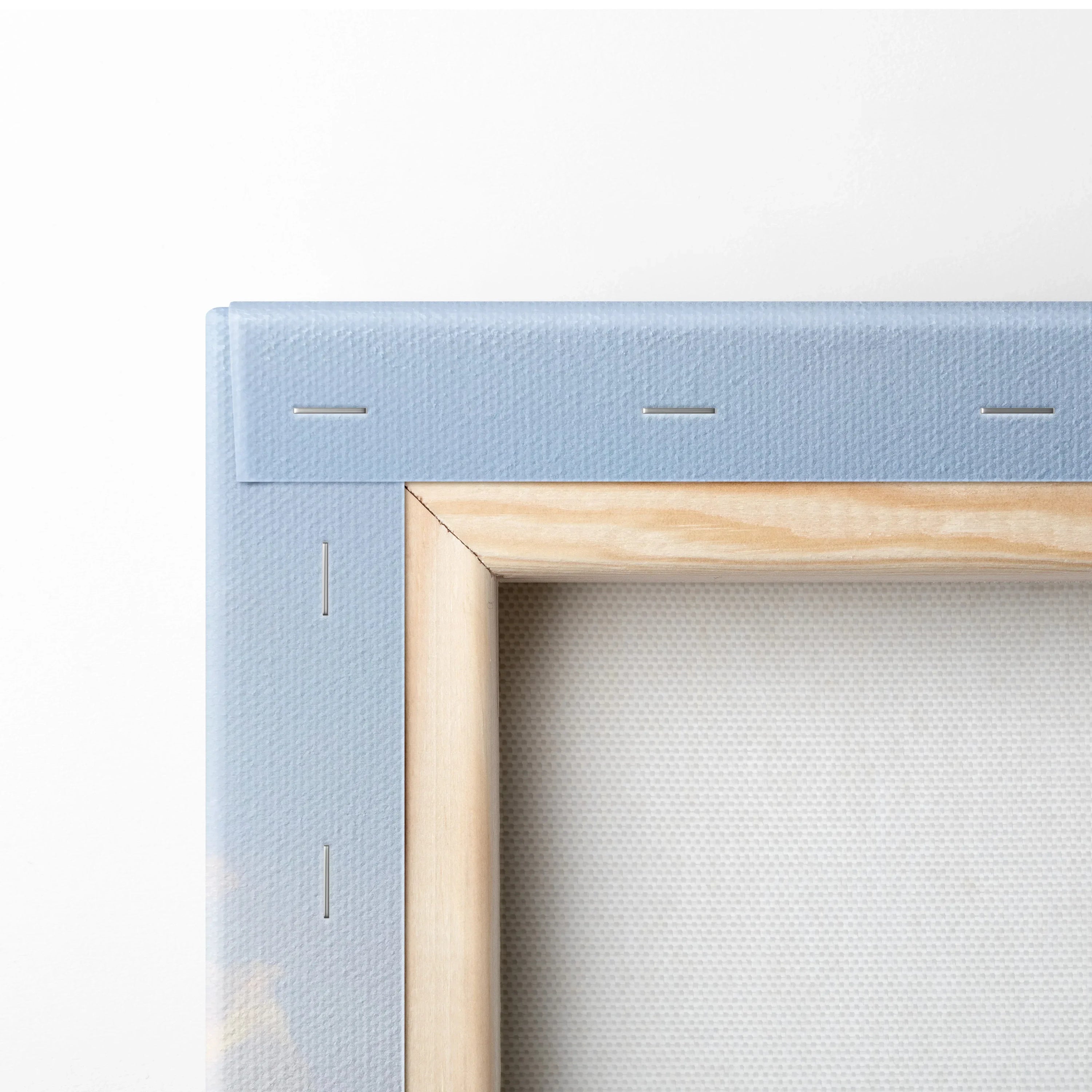 Close-up of light blue canvas stretched on wood frame with visible staples, showcasing museum-quality canvas art.
