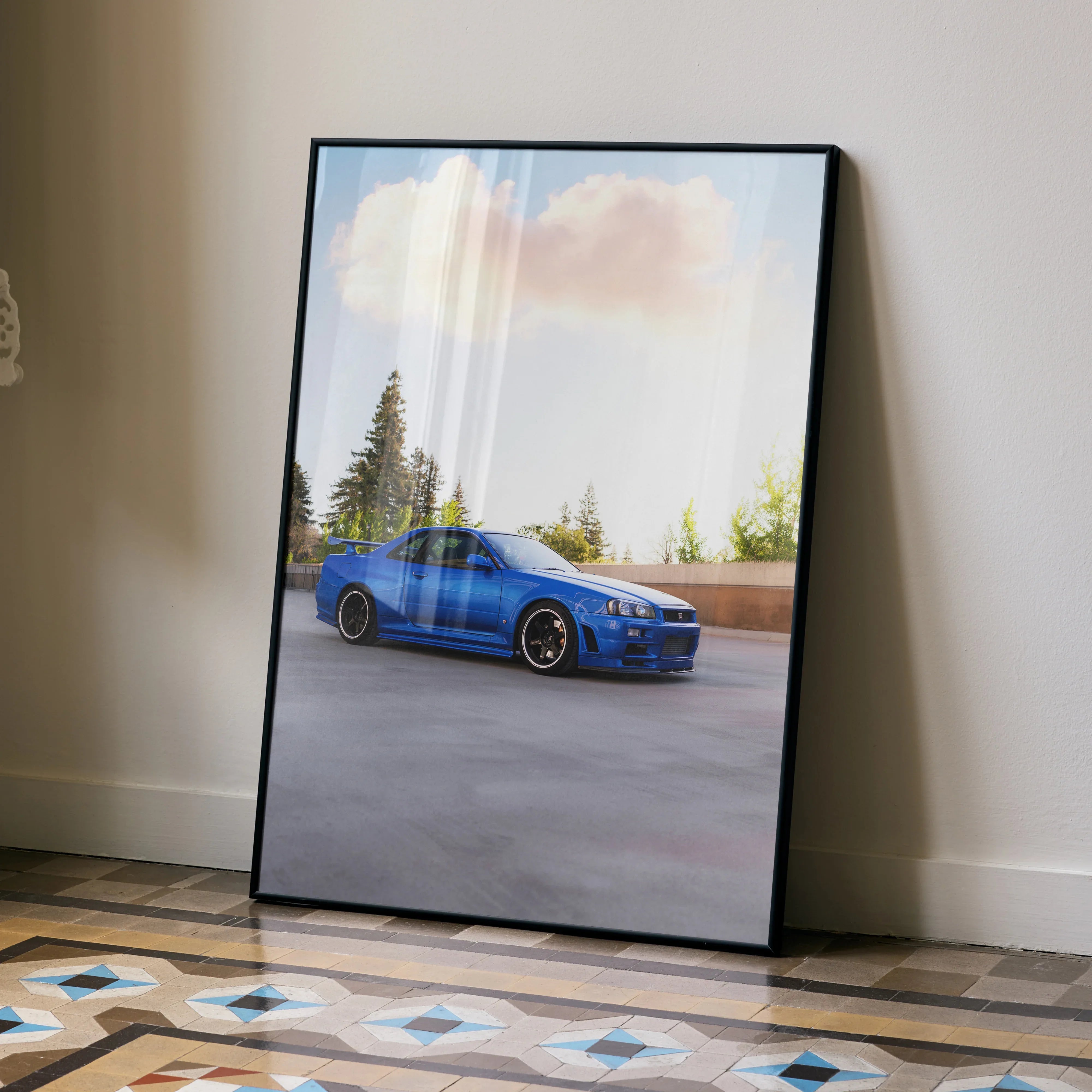 Blue Nissan R34 GTR car parked with trees and clouds in background poster wall art.