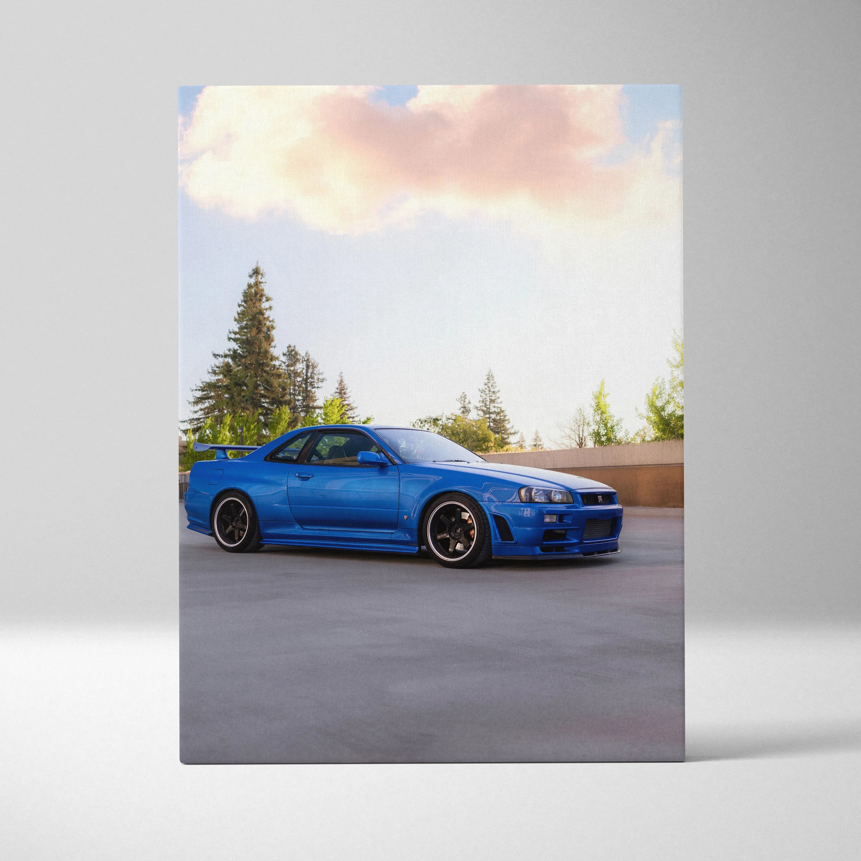 Nissan R34 GTR blue sports car on vertical canvas wall art with outdoor background and pine trees.