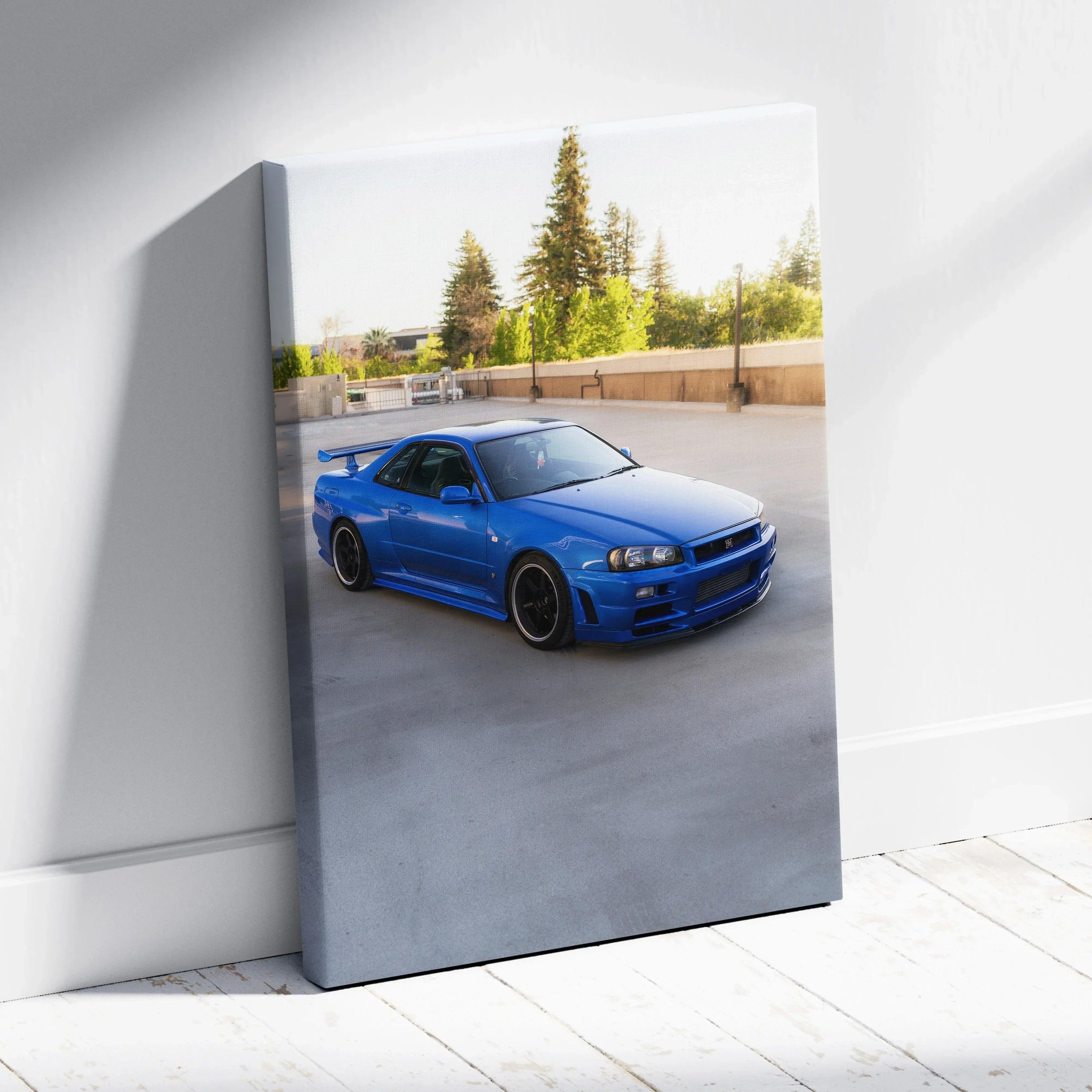 Vertical canvas art featuring a vibrant blue Nissan R34 GTR parked outdoors in bright sunlight.