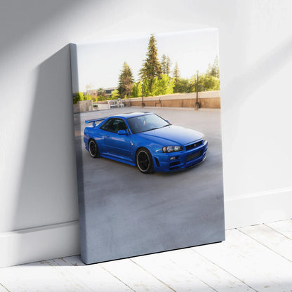 Vertical canvas art featuring a vibrant blue Nissan R34 GTR parked outdoors in bright sunlight.