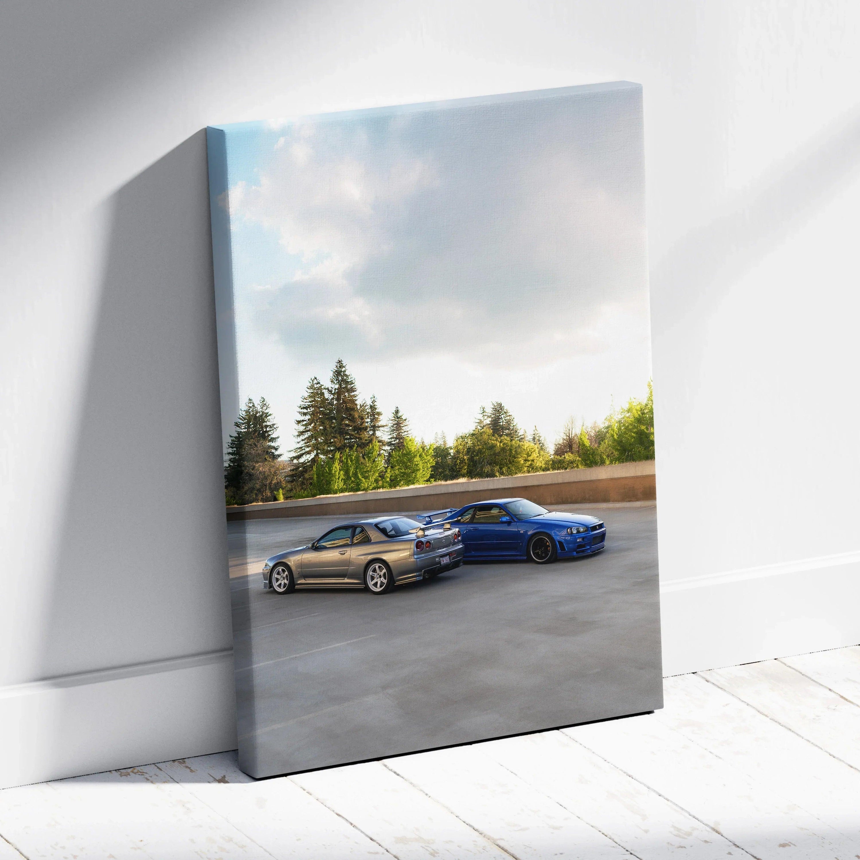 Nissan R34 GTR twin cars racing on open road vertical canvas wall art with blue sky and trees.