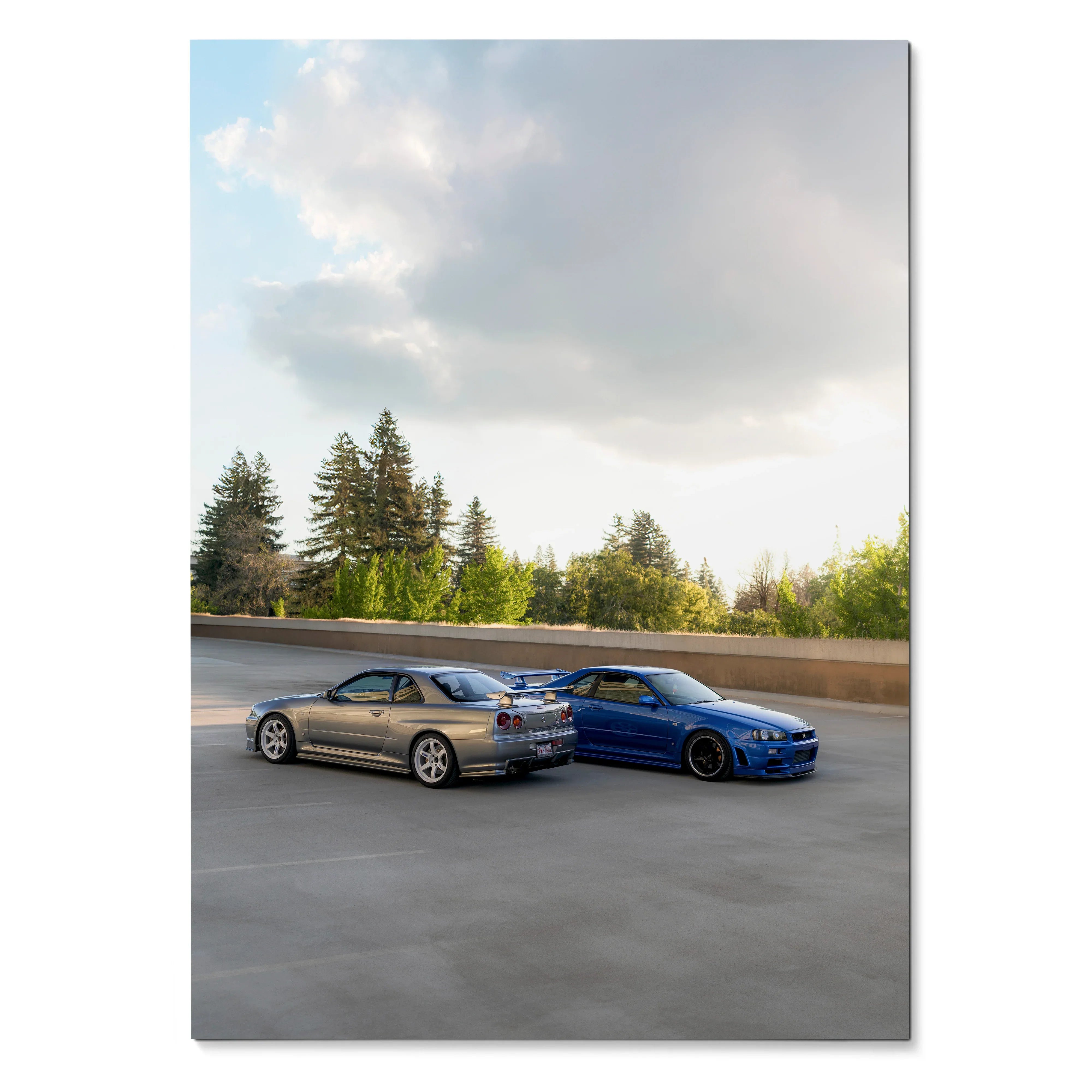 Nissan R34 GTR Skyline poster featuring blue and silver cars under a cloudy sky, wall art with sunset tones.