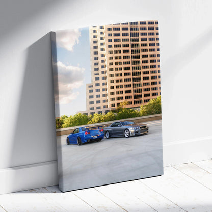Vertical canvas wall art featuring two Nissan R34 GTRs parked on a rooftop against a cityscape background.