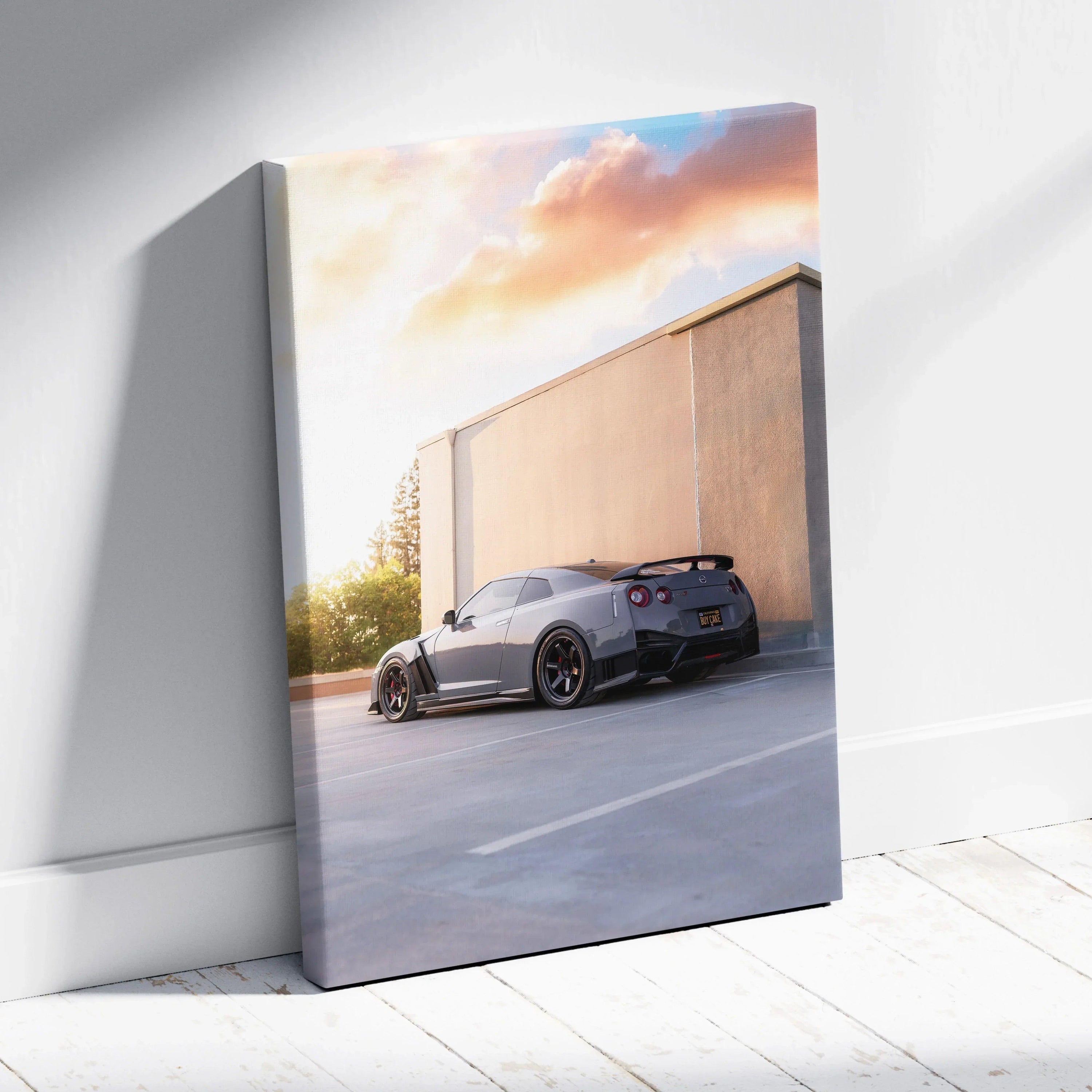 Vertical canvas wall art featuring a sleek black Nissan R35 GTR at sunset against a concrete wall.