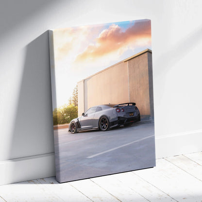 Vertical canvas wall art featuring a sleek black Nissan R35 GTR at sunset against a concrete wall.