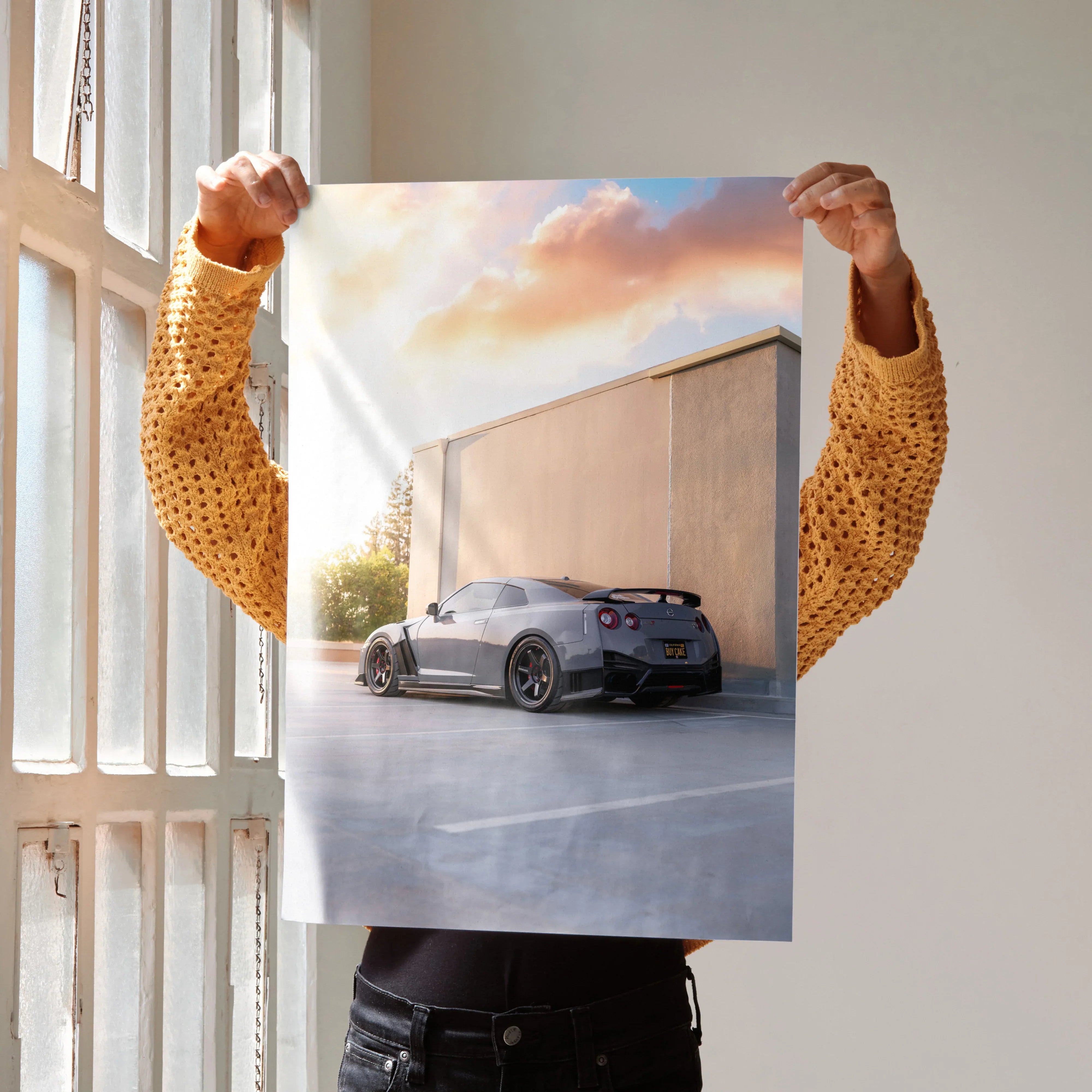 Nissan GTR R35 poster with gray car parked by modern building under pink sunset sky, wall art.